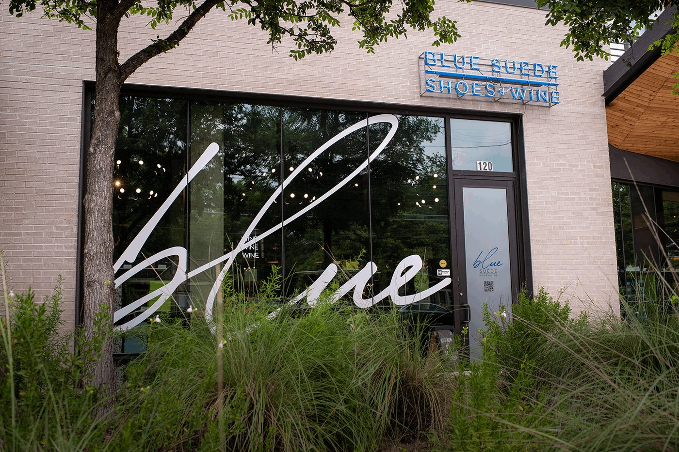 Storefront window graphics with large script lettering.