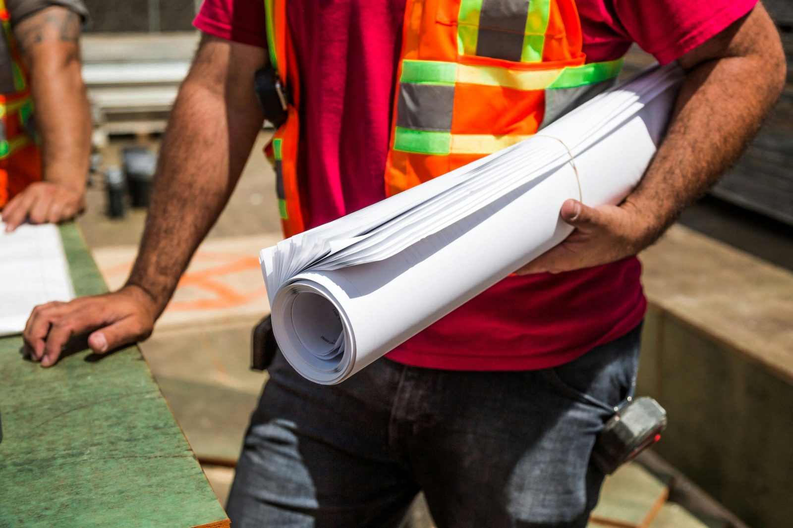 Rolled construction documents being carried on a jobsite.
